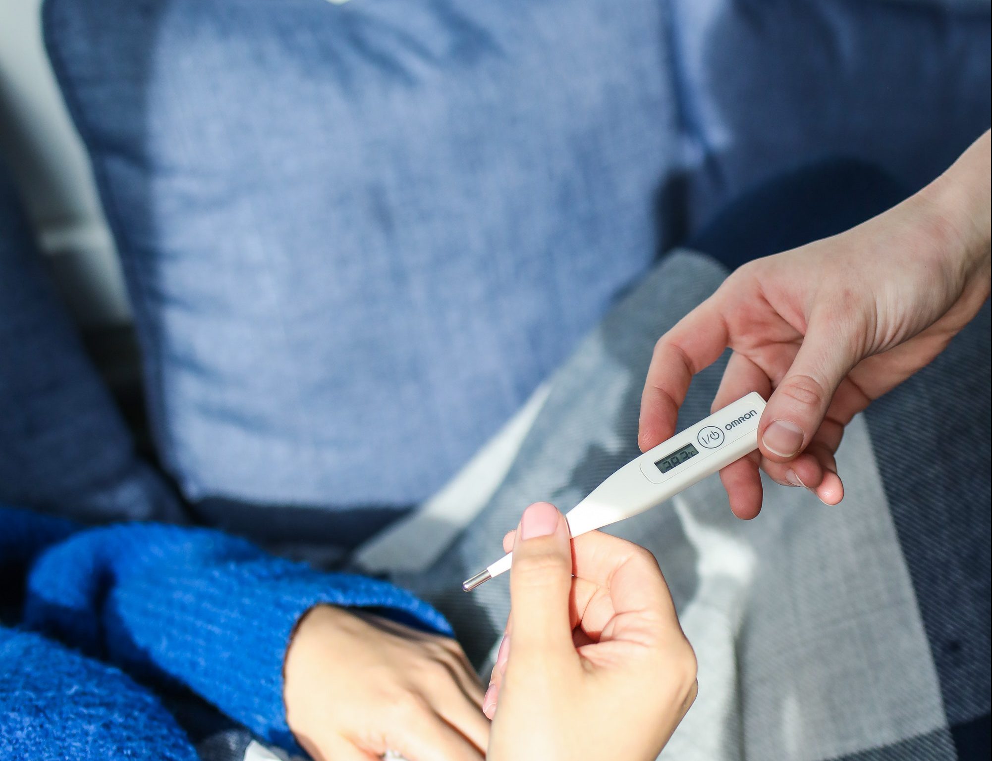 person sick with thermometer