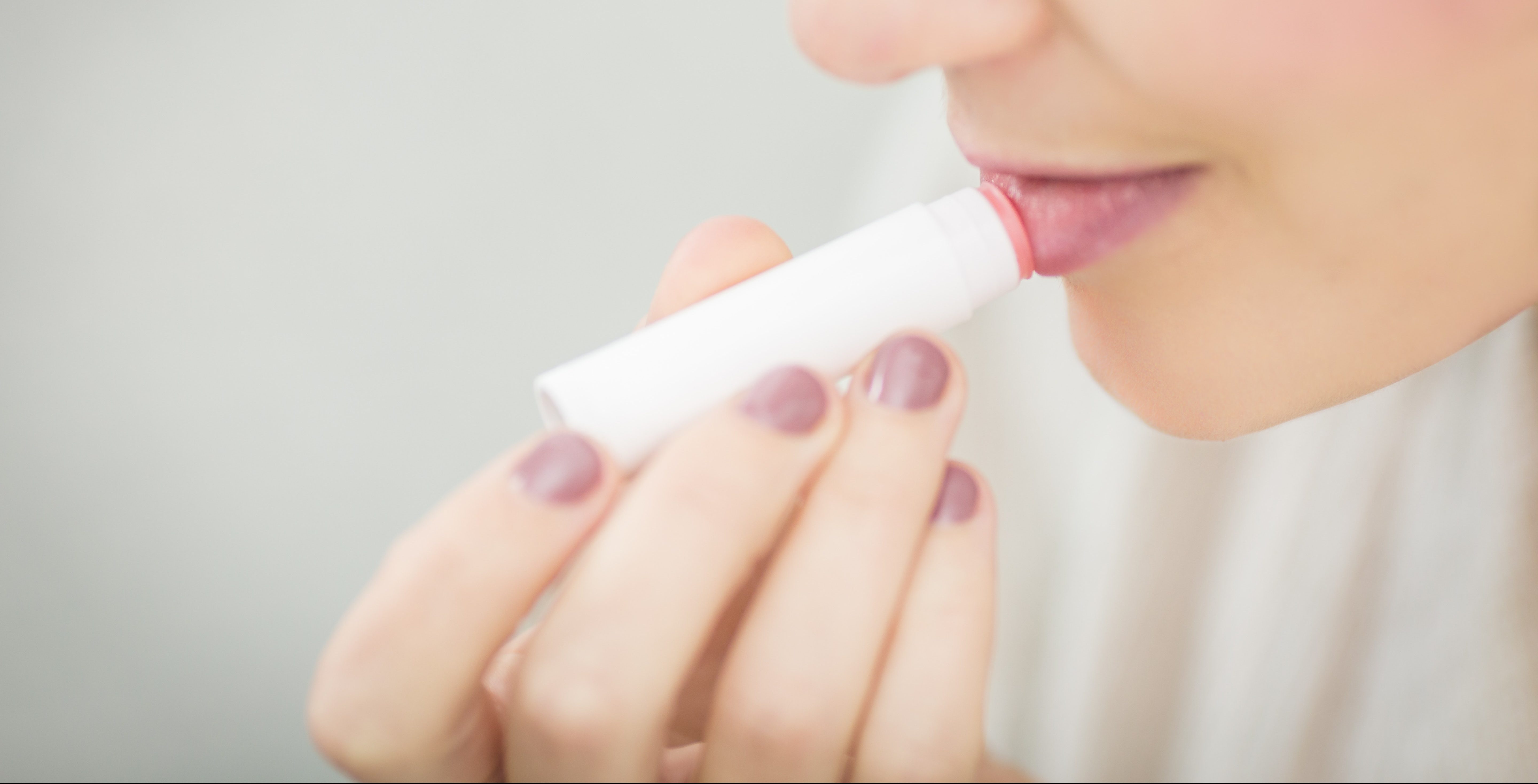 woman putting on lip balm