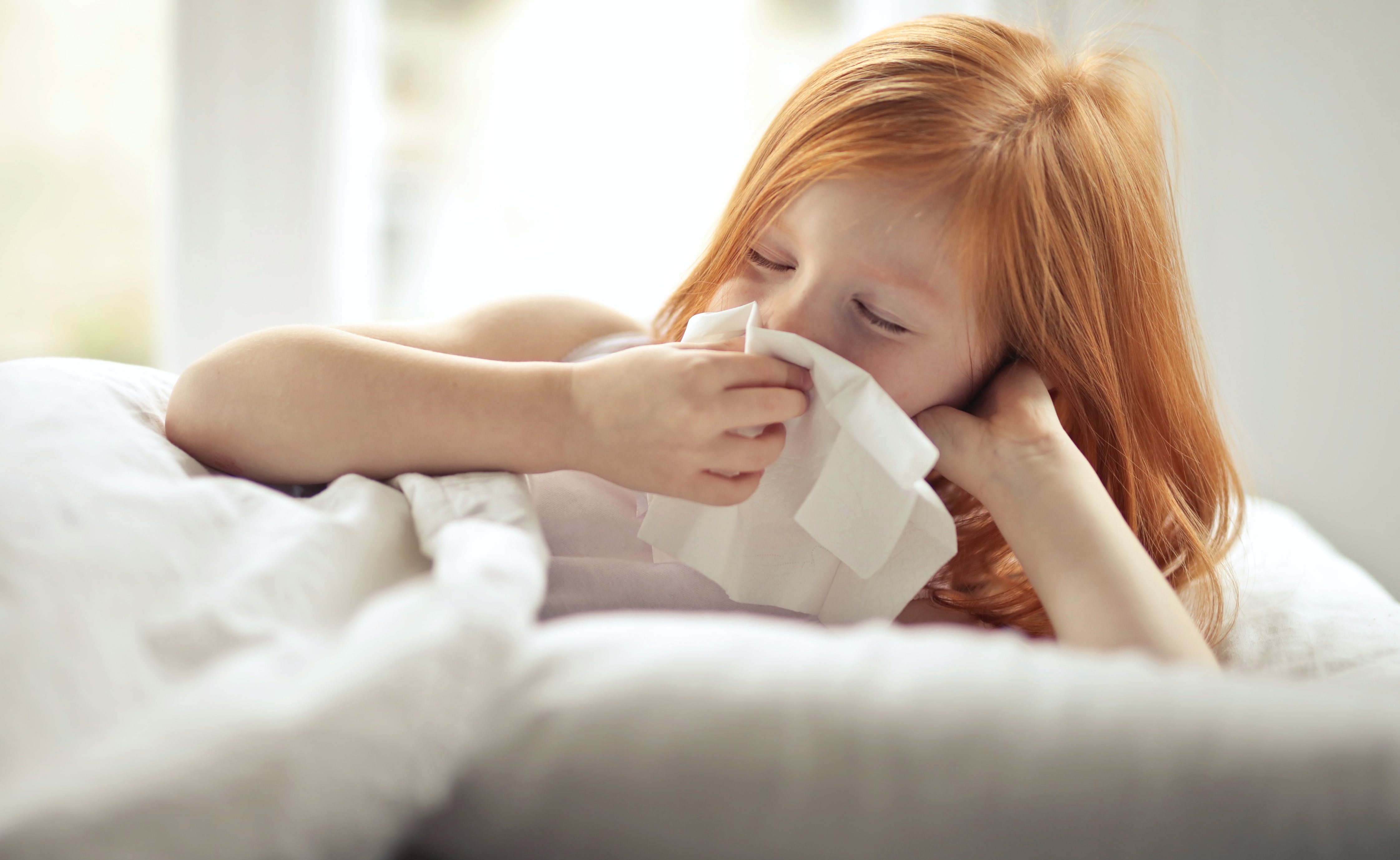 child blowing her nose