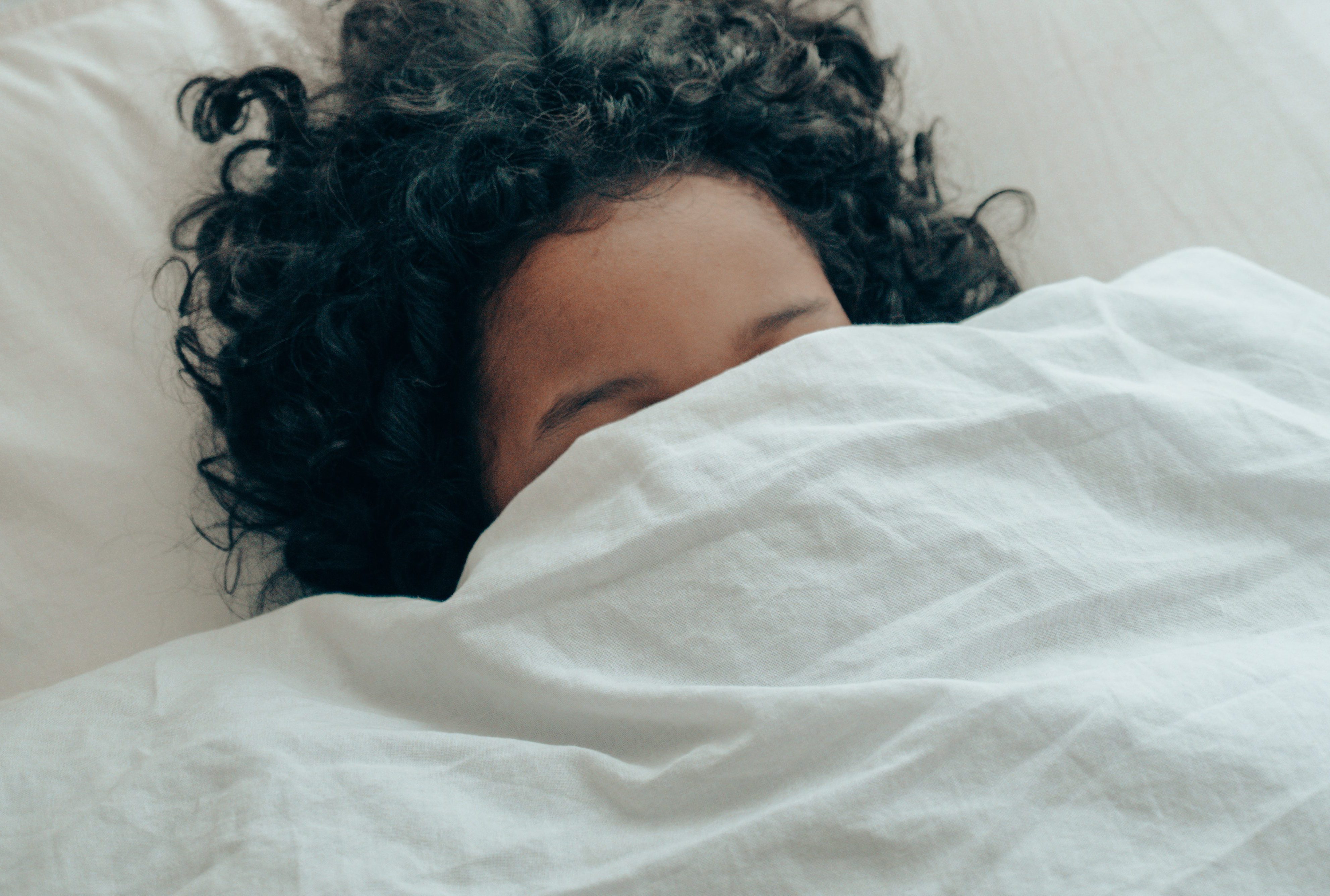 woman sleeping under covers